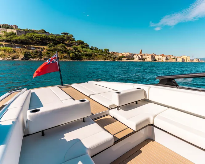 Greenwich Yacht Photos Pics Luxurious 2022 Wajer 55 yacht with white seating, cruising near scenic coastline.