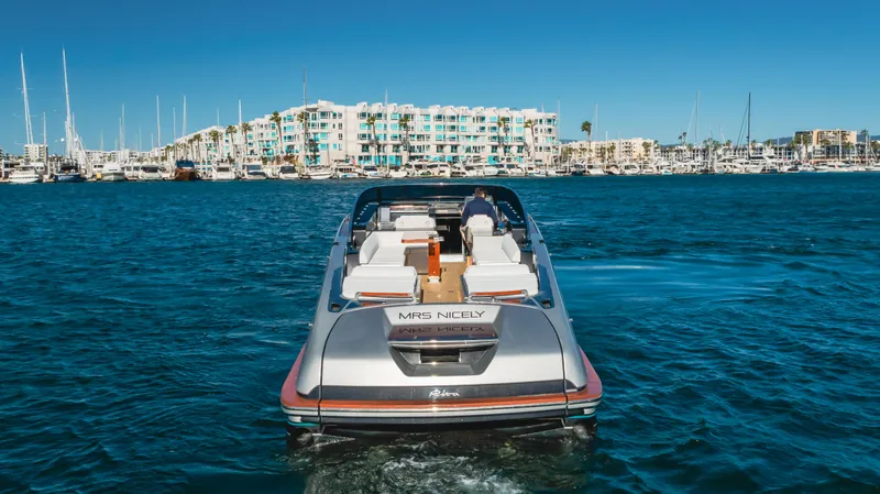 Mrs. Nicely Yacht Photos Pics 2020 Riva Dolceriva luxury yacht cruising in a marina with waterfront buildings.