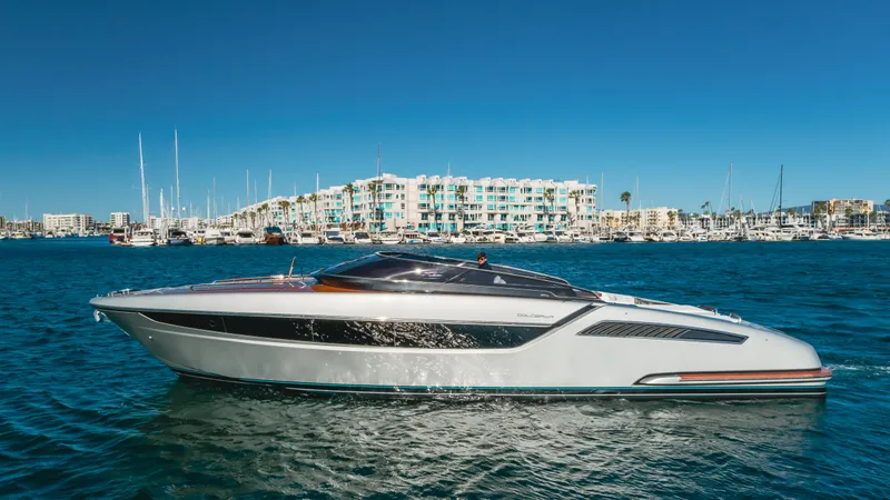 Mrs. Nicely Yacht Photos Pics 2020 Riva Dolceriva luxury yacht cruising in a marina with modern buildings in the background.