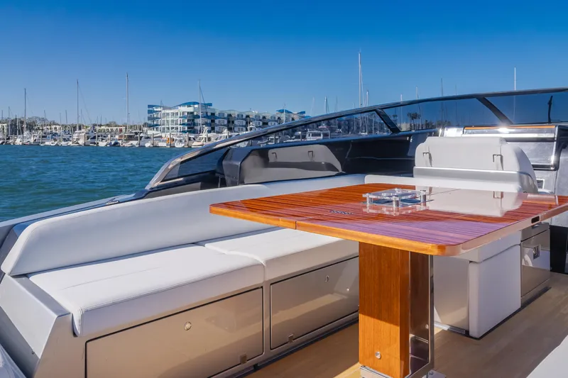 Mrs. Nicely Yacht Photos Pics 2020 Riva Dolceriva yacht with elegant seating and wooden table, docked in a marina.