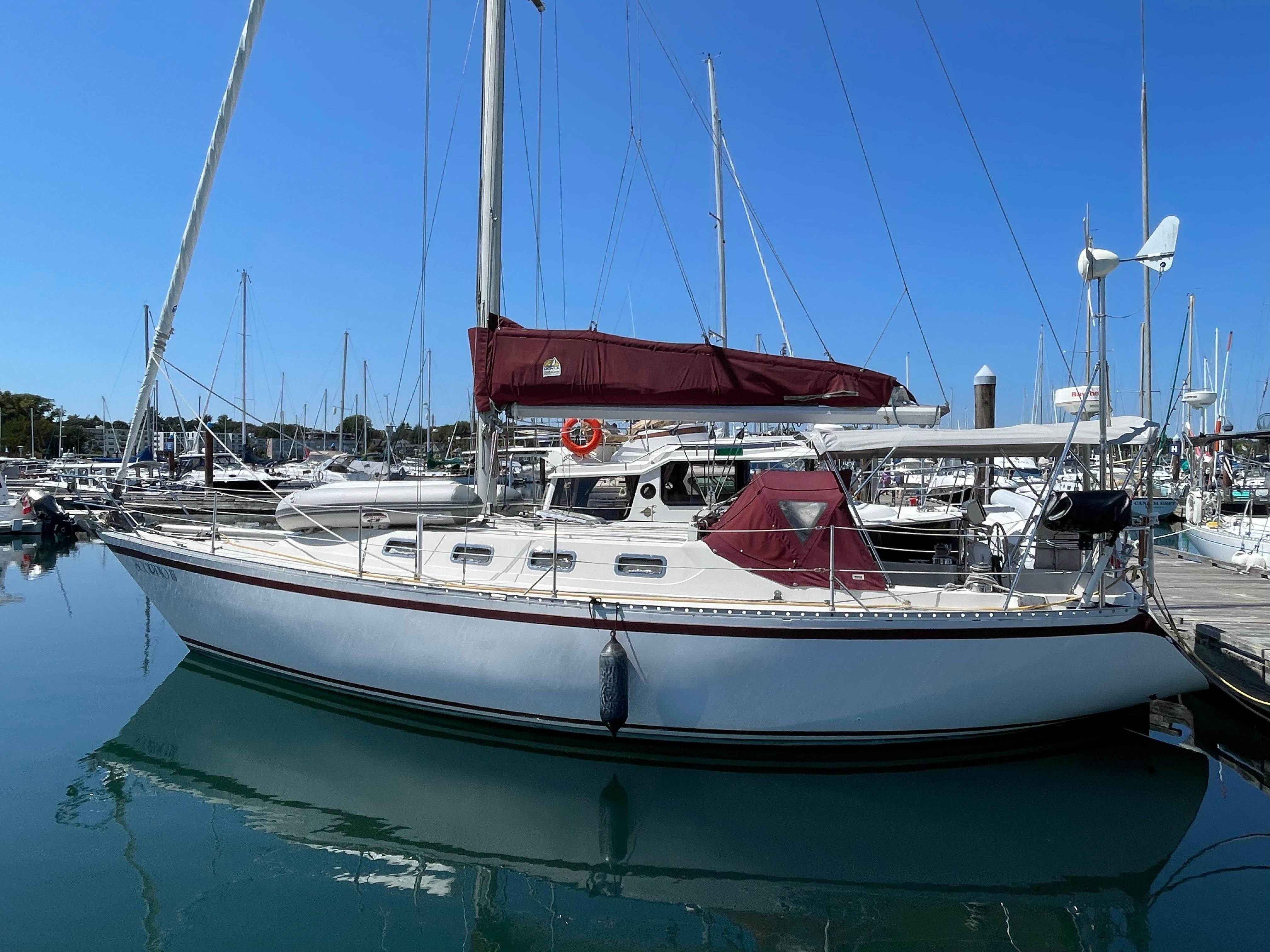 1980 CS 36 Traditional sailboat docked in marina, clear blue sky, calm water.