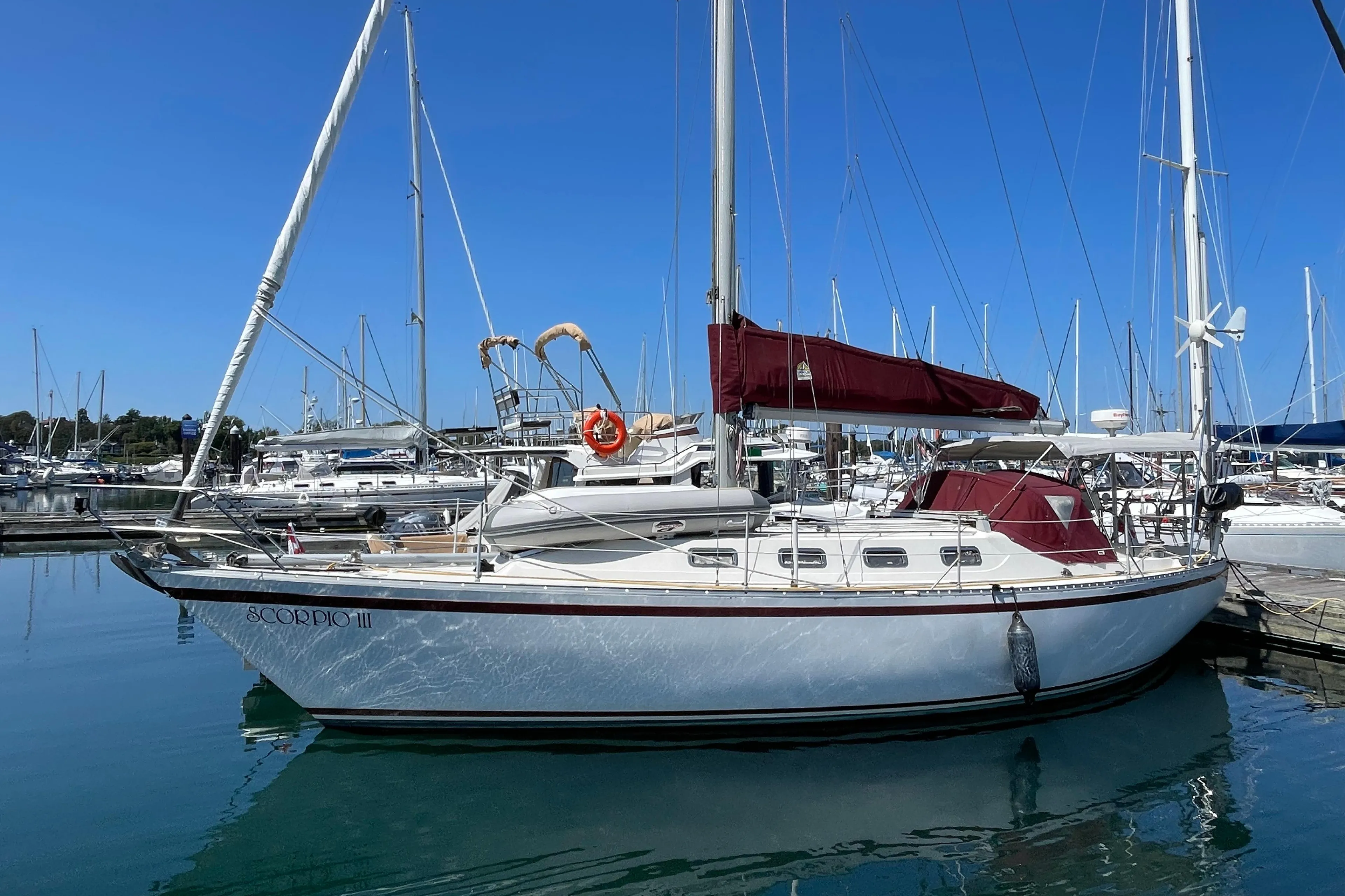 1980 CS 36 Traditional sailboat docked in a marina under clear blue skies.