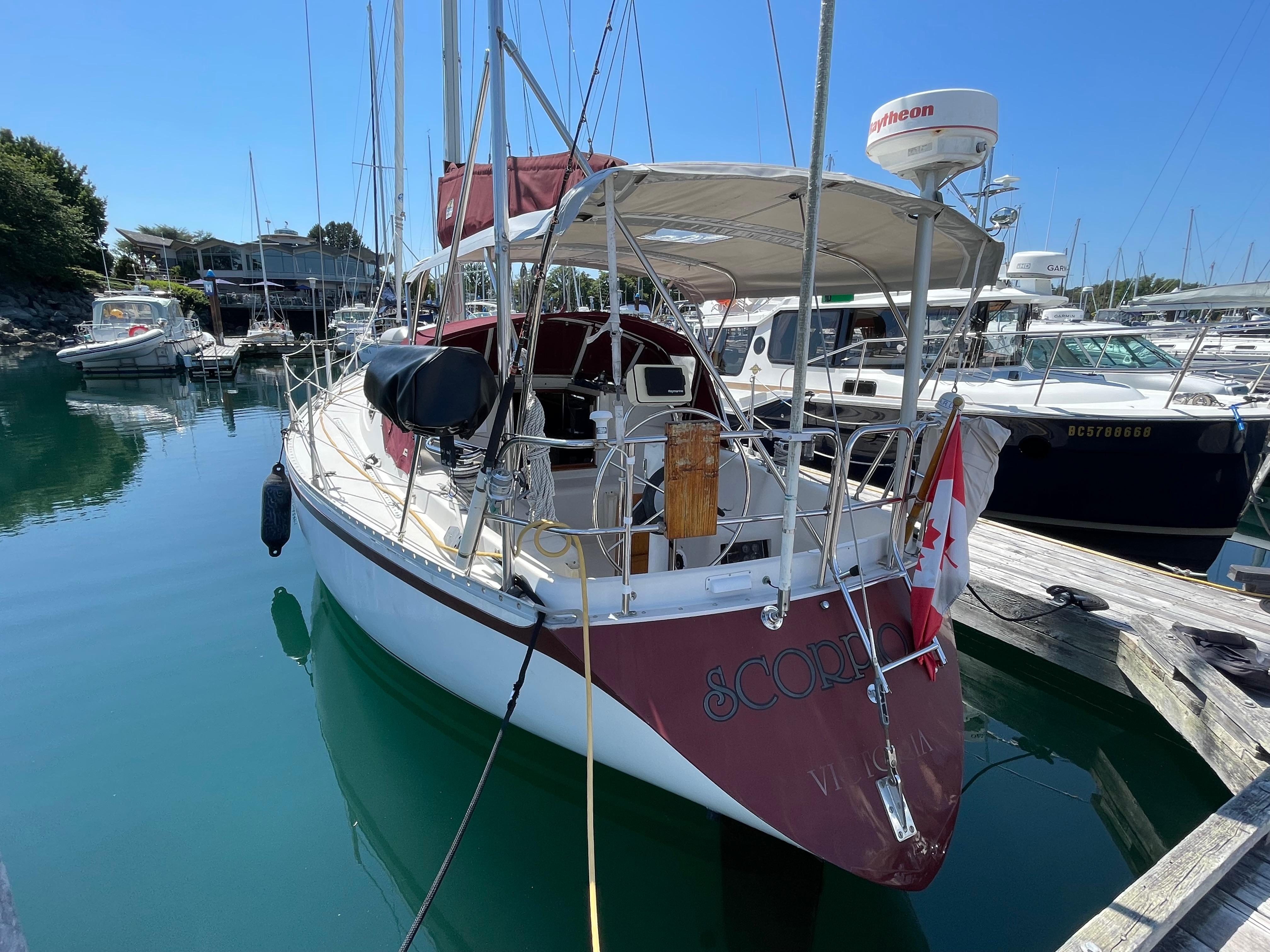 1980 CS 36 Traditional sailboat docked in a marina, featuring a Canadian flag.