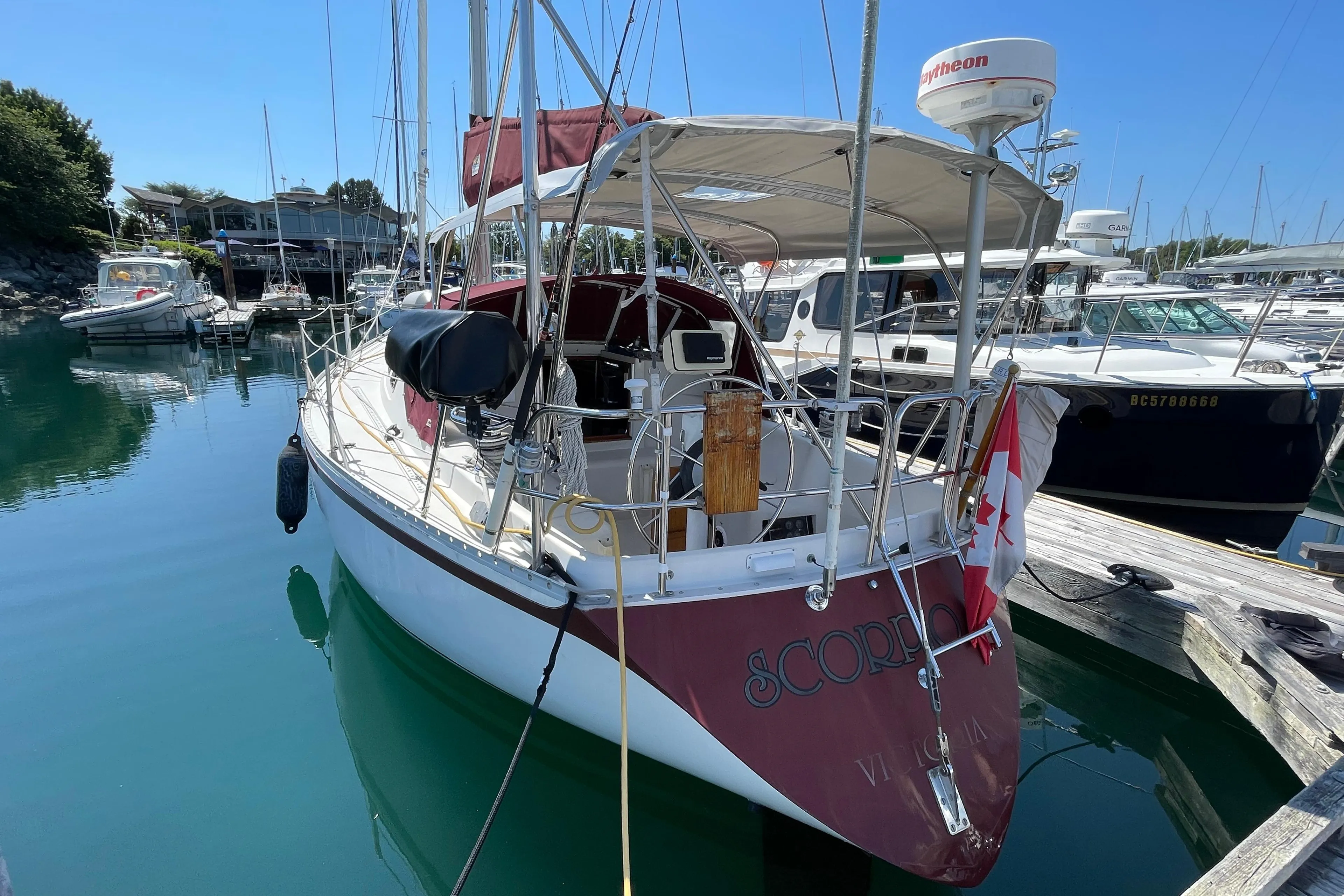 1980 CS 36 Traditional sailboat docked in a marina, featuring a Canadian flag.