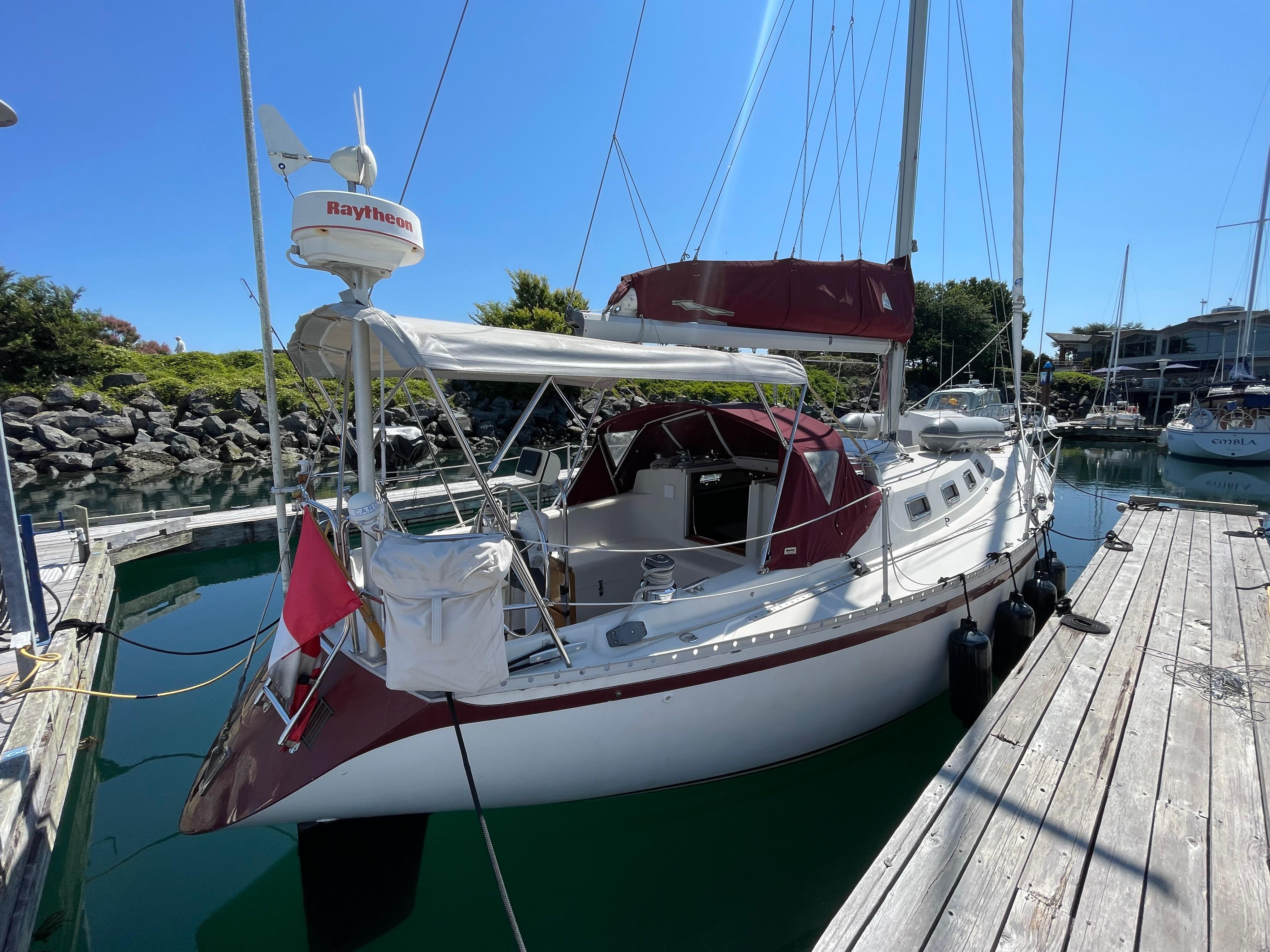 1980 CS 36 Traditional sailboat docked in marina, featuring maroon accents and Raytheon equipment.