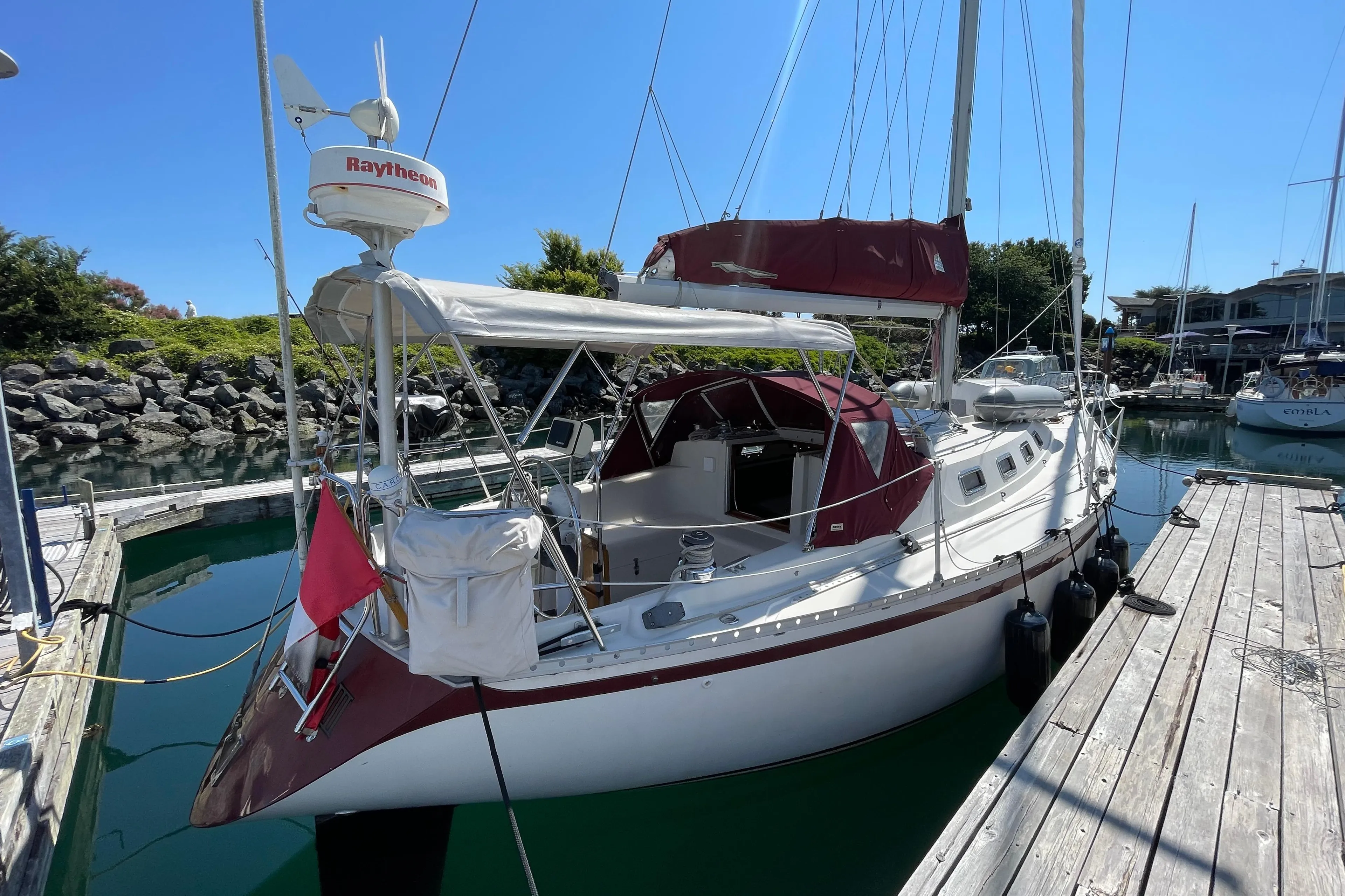 1980 CS 36 Traditional sailboat docked in marina, featuring maroon accents and Raytheon equipment.