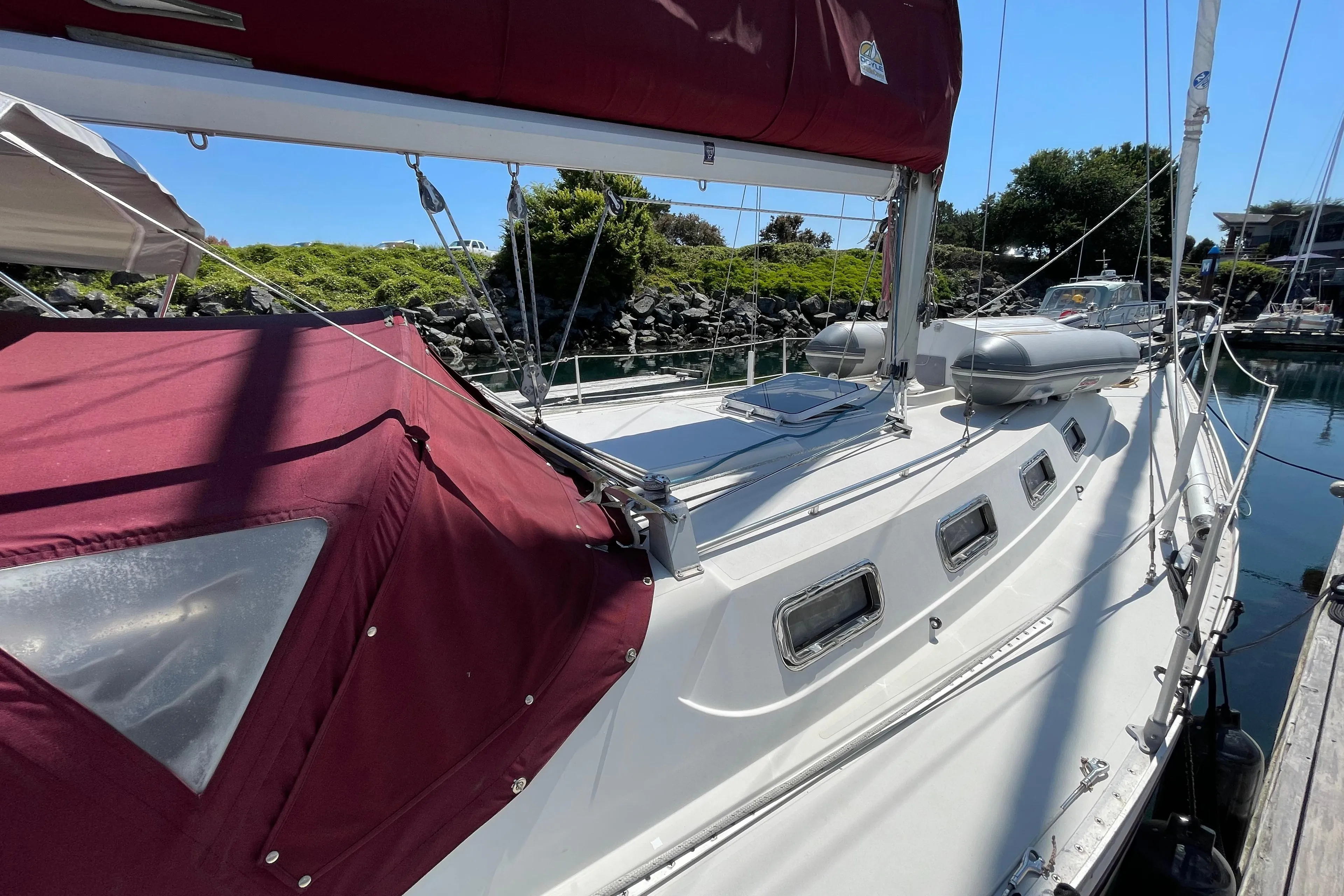 1980 CS 36 Traditional sailboat docked, featuring maroon canopy and sleek white deck.