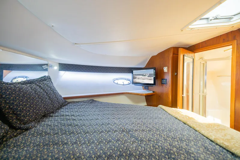 Mar's Bar Yacht Photos Pics Luxurious cabin interior of a 2000 Tiara Yachts Open model with a cozy bed and TV.