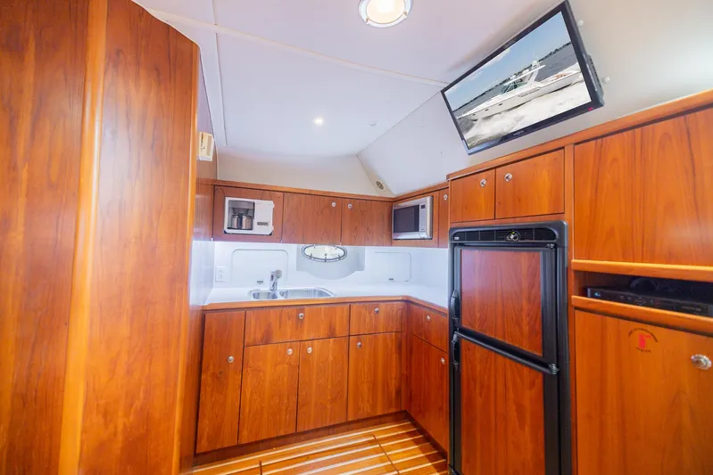 Mar's Bar Yacht Photos Pics 2000 Tiara Yachts Open model kitchen with wooden cabinetry and modern appliances.
