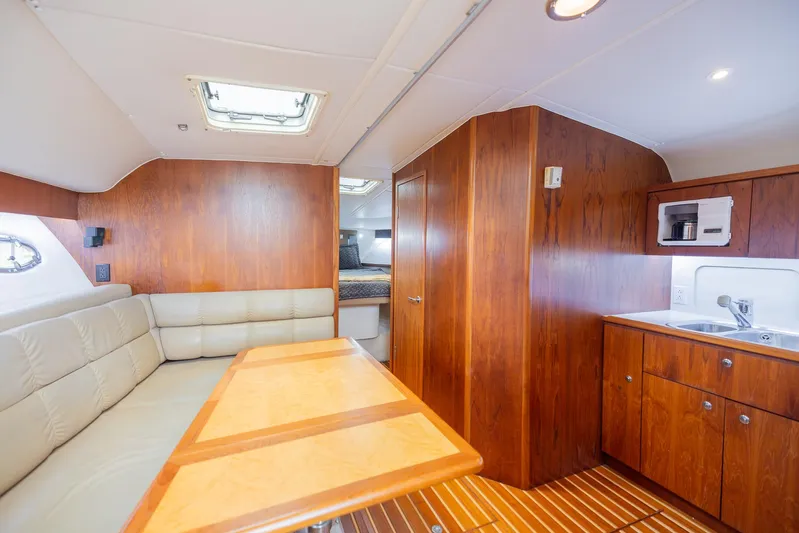 Mar's Bar Yacht Photos Pics 2000 Tiara Yachts Open interior with wood finishes, dining area, and kitchenette.