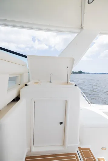 Mar's Bar Yacht Photos Pics 2000 Tiara Yachts Open model with onboard sink and storage, docked on a serene waterway.