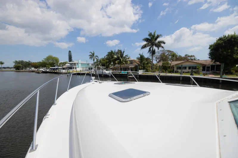Mar's Bar Yacht Photos Pics 2000 Tiara Yachts Open boat docked near waterfront homes under a partly cloudy sky.