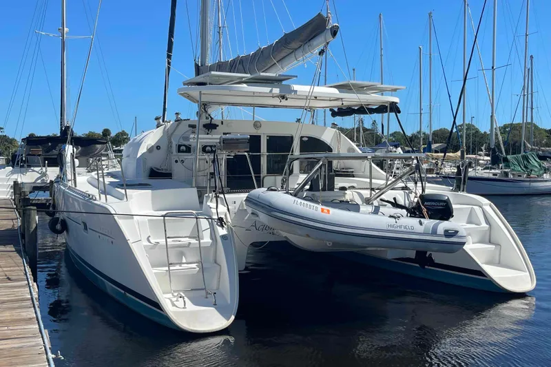 Acushla Yacht Photos Pics 2003 Lagoon 410-S2 catamaran docked with inflatable boat, clear blue sky background.