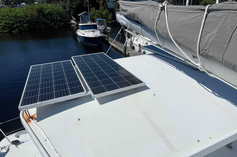 Acushla Yacht Photos Pics Solar panels on 2003 Lagoon 410-S2 catamaran docked by water.