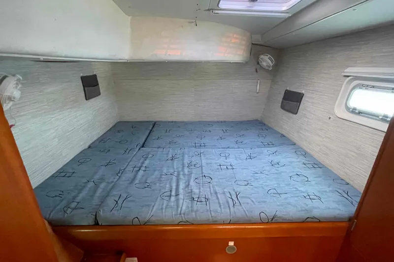 Acushla Yacht Photos Pics Cozy cabin interior of 2003 Lagoon 410-S2 catamaran with double bed and porthole.