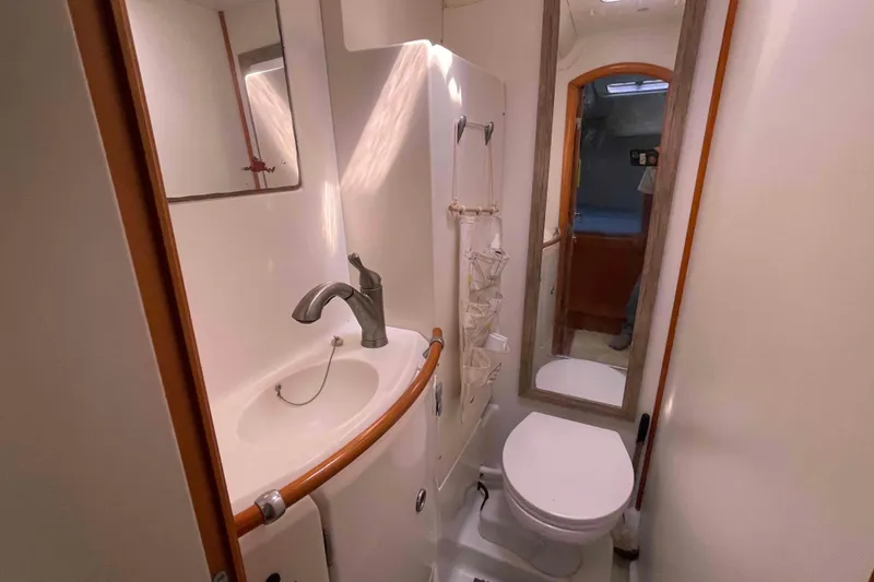 Acushla Yacht Photos Pics Compact bathroom in a 2003 Lagoon 410-S2 yacht, featuring a sink, mirror, and toilet.