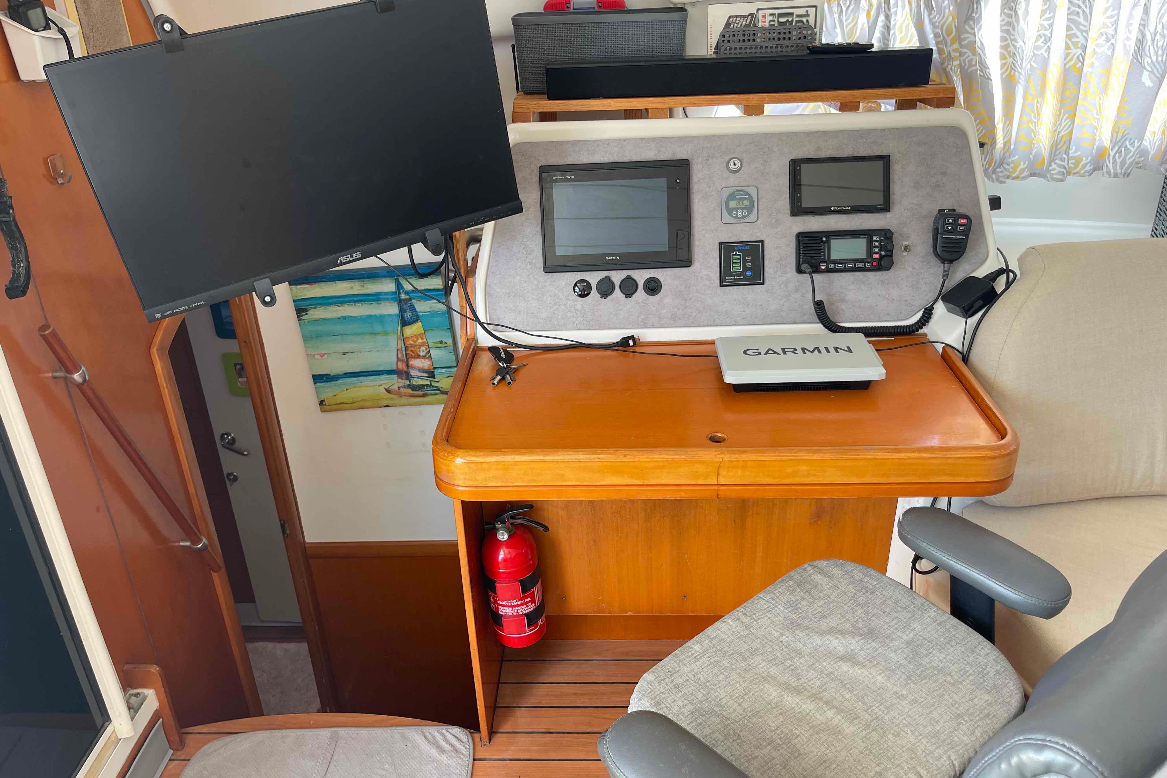 Navigation station of 2003 Lagoon 410-S2 catamaran with Garmin equipment and fire extinguisher.