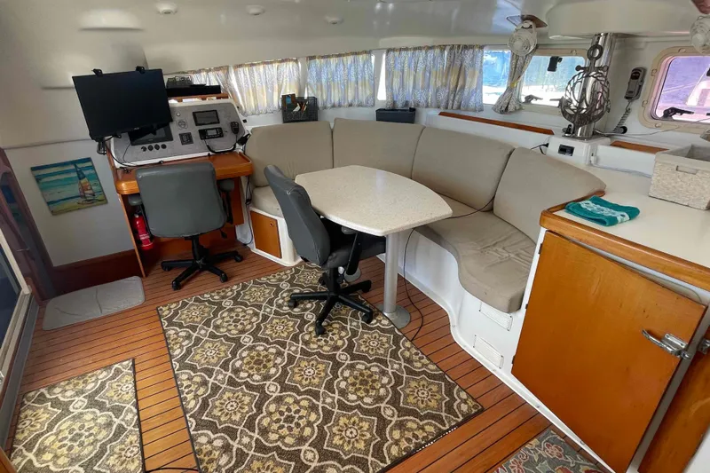 Acushla Yacht Photos Pics Interior of 2003 Lagoon 410-S2 catamaran with seating, table, and navigation station.