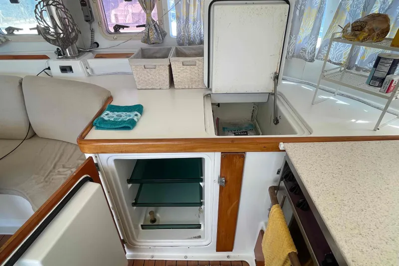 Acushla Yacht Photos Pics Interior of 2003 Lagoon 410-S2 yacht kitchen with open fridge and storage.
