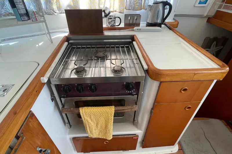 Acushla Yacht Photos Pics Compact kitchen area in a 2003 Lagoon 410-S2 yacht with stove and kettle.