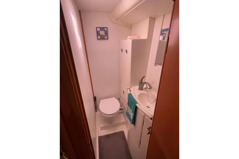Acushla Yacht Photos Pics Compact bathroom in a 2003 Lagoon 410-S2 yacht, featuring a toilet and sink.