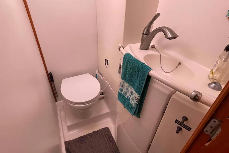 Acushla Yacht Photos Pics Compact bathroom in a 2003 Lagoon 410-S2 yacht with toilet and sink.