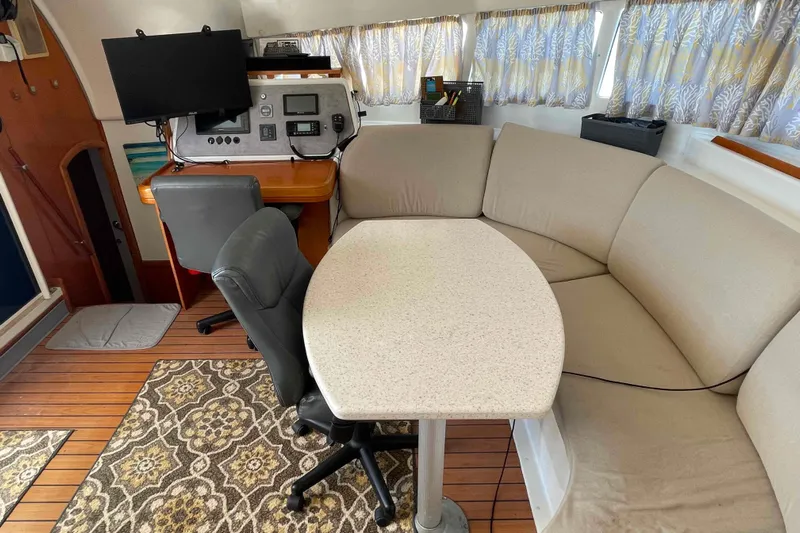 Acushla Yacht Photos Pics Interior of 2003 Lagoon 410-S2 catamaran with seating, table, and navigation station.