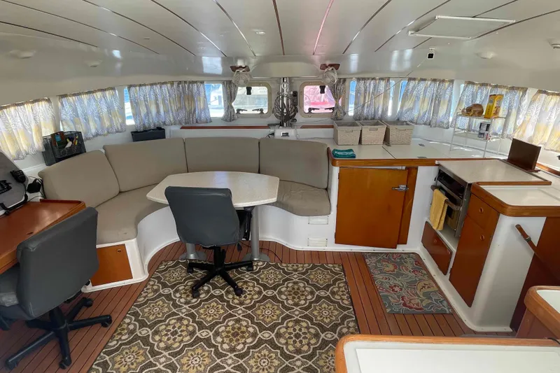 Acushla Yacht Photos Pics Interior of 2003 Lagoon 410-S2 catamaran with cozy seating and wooden cabinetry.