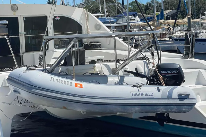 Acushla Yacht Photos Pics 2003 Lagoon 410-S2 catamaran with Highfield dinghy and Mercury outboard motor at marina.