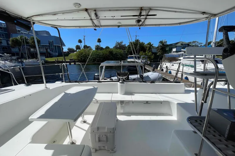 Acushla Yacht Photos Pics 2003 Lagoon 410-S2 catamaran cockpit with seating, table, and marina view.