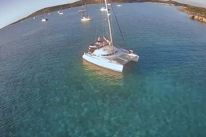 Acushla Yacht Photos Pics 2003 Lagoon 410-S2 catamaran anchored in clear blue waters, surrounded by other boats.