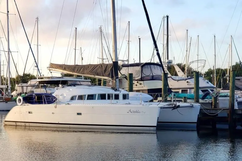 Acushla Yacht Photos Pics 2003 Lagoon 410-S2 catamaran docked at a marina with sailboats.