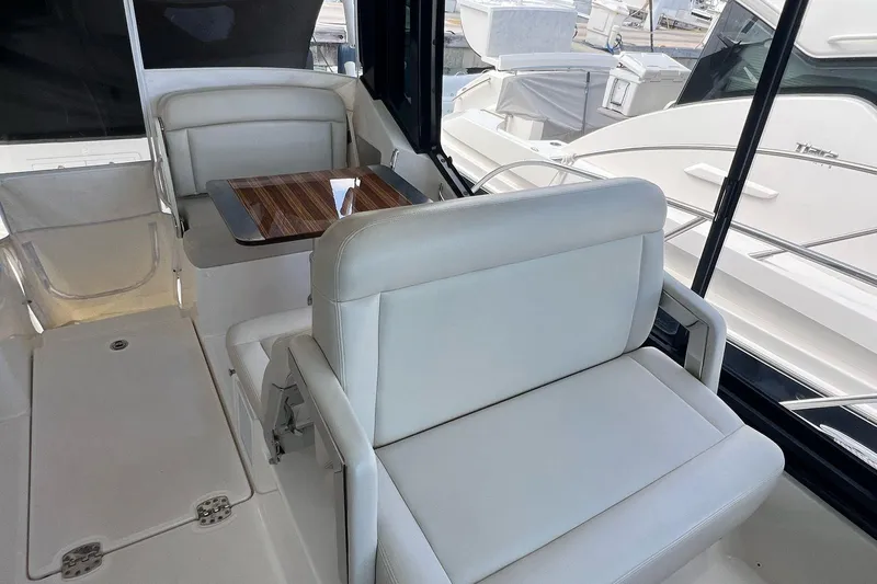  Yacht Photos Pics 2022 Boston Whaler Conquest 405 interior with white seating and wooden table.