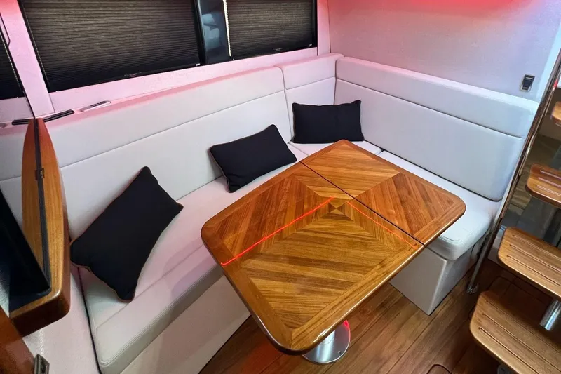  Yacht Photos Pics Luxurious interior of 2022 Boston Whaler Conquest 405 with elegant wood table and plush seating.