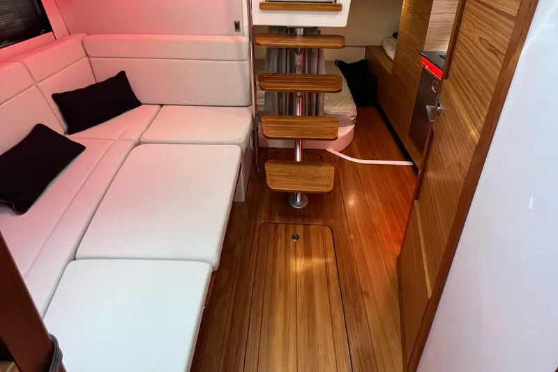  Yacht Photos Pics Luxurious interior of 2022 Boston Whaler Conquest 405 with white seating and wooden flooring.