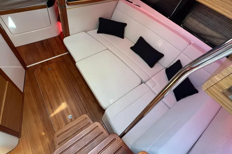  Yacht Photos Pics Luxurious interior of 2022 Boston Whaler Conquest 405 with white seating and wooden flooring.