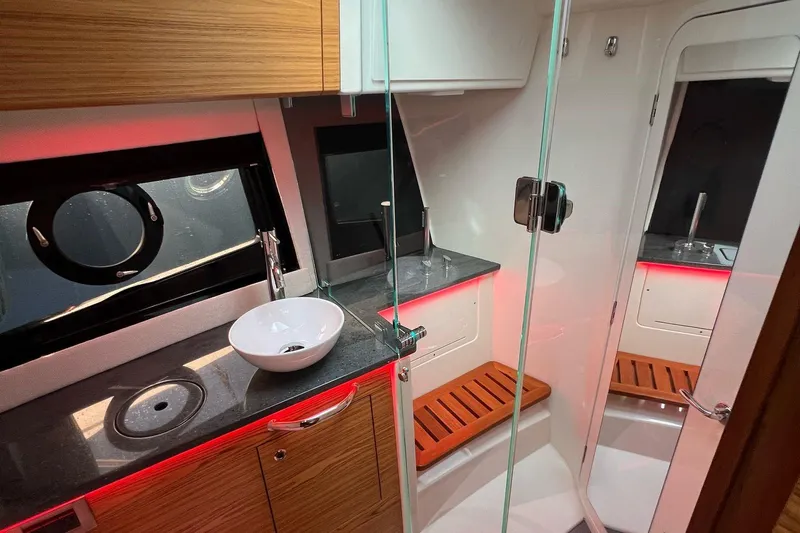  Yacht Photos Pics Luxurious bathroom interior of 2022 Boston Whaler Conquest 405 with modern fixtures and wood accents.
