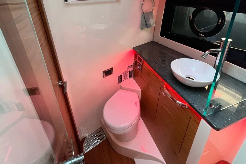  Yacht Photos Pics Luxurious bathroom in 2022 Boston Whaler Conquest 405 yacht with modern fixtures and ambient lighting.