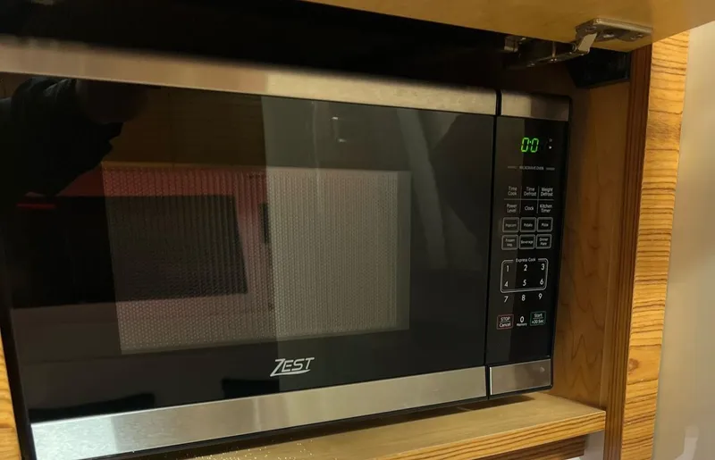  Yacht Photos Pics Zest microwave oven in wooden cabinet, digital display showing zero.