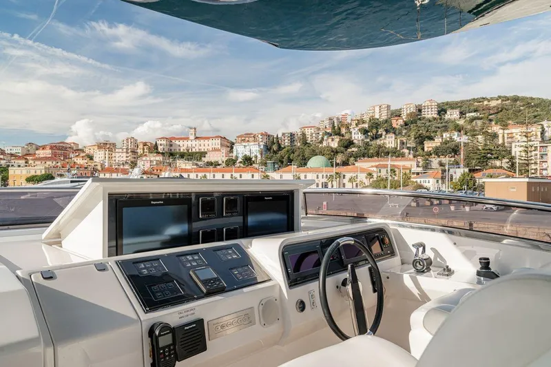7 Seconds Yacht Photos Pics Cockpit view of 2015 Dreamline 26 yacht with scenic coastal town backdrop.