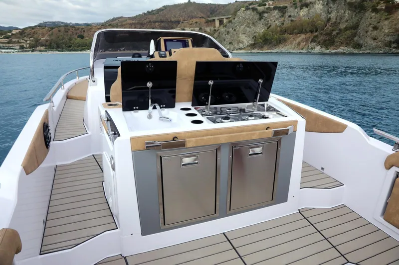 Yacht Photos Pics 2025 Ranieri NEXT 330 XL yacht with outdoor kitchen on deck, cruising near scenic coastline.
