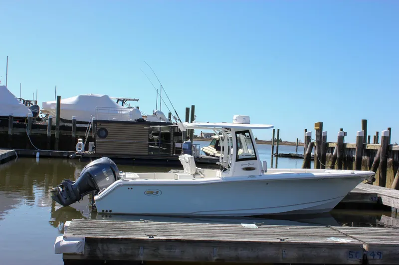  Yacht Photos Pics 2023 Sea Hunt Gamefish 27 with Coffin Box docked at a marina under clear blue skies.