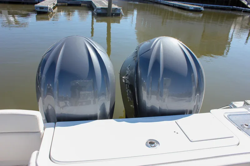  Yacht Photos Pics Twin outboard engines on a 2023 Sea Hunt Gamefish 27 with Coffin Box, docked in calm water.