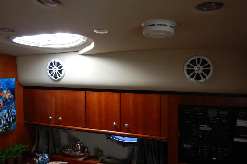 Sunny Daze Yacht Photos Pics 2007 Cruisers 340 Express cabin interior with wood cabinets and ceiling speakers.