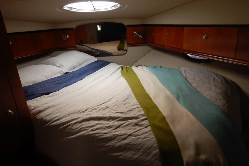 Sunny Daze Yacht Photos Pics Cozy cabin interior of 2007 Cruisers 340 Express with bed and wooden cabinets.