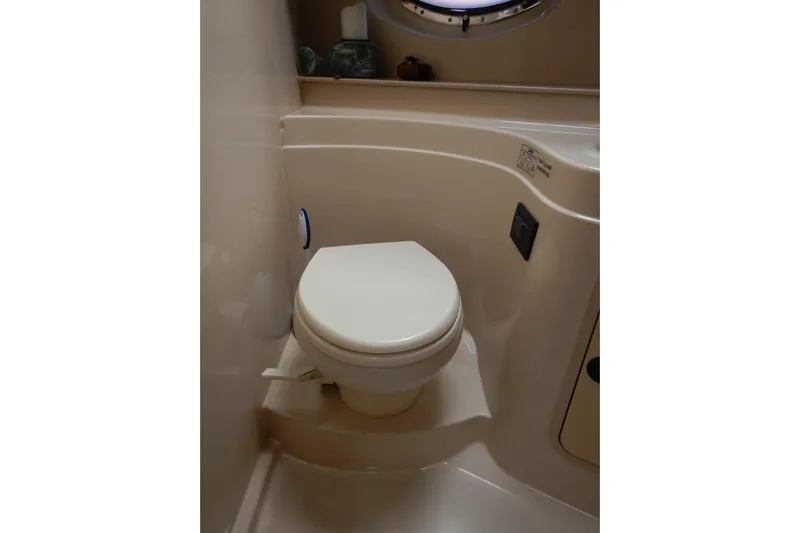 Sunny Daze Yacht Photos Pics 2007 Cruisers 340 Express boat bathroom with compact toilet and porthole window.