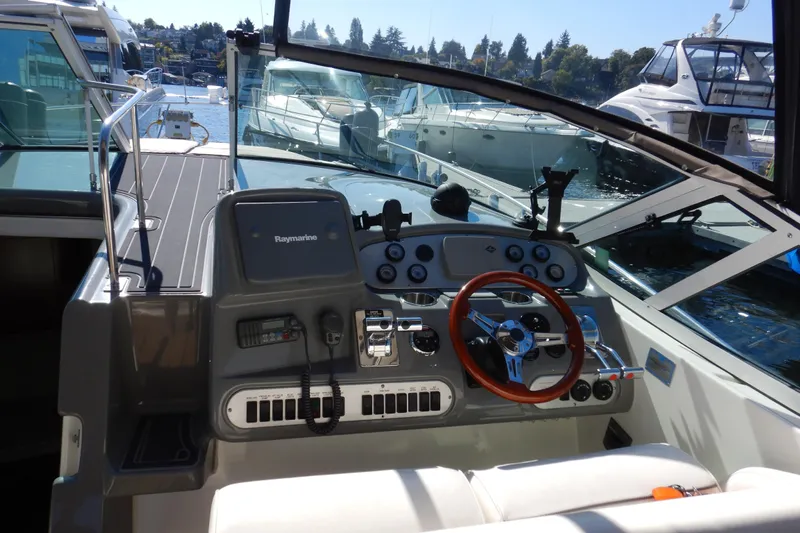 Sunny Daze Yacht Photos Pics 2007 Cruisers 340 Express boat cockpit with steering wheel and control panel, docked at marina.