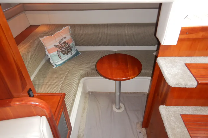 Sunny Daze Yacht Photos Pics 2007 Cruisers 340 Express cabin interior with seating, table, and turtle-themed pillow.