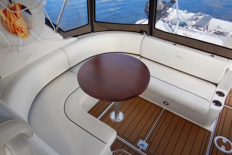 Sunny Daze Yacht Photos Pics 2007 Cruisers 340 Express yacht interior with white seating and wooden table.