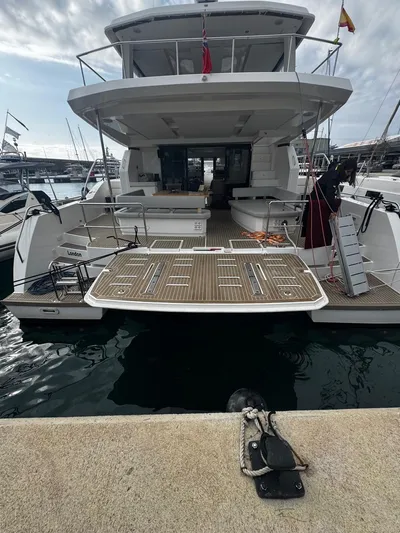Plan C Yacht Photos Pics 2024 Leopard 53 Powercat yacht docked at marina, rear view showcasing spacious deck.